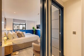 Une chambre d’hôtel moderne, dotée d’un grand lit, d’un bureau et d’une chaise.