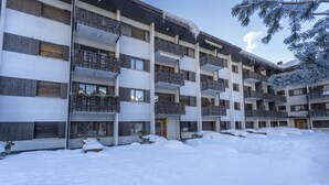 Ett hotell med flera våningar, balkonger och en snötäckt innergård.