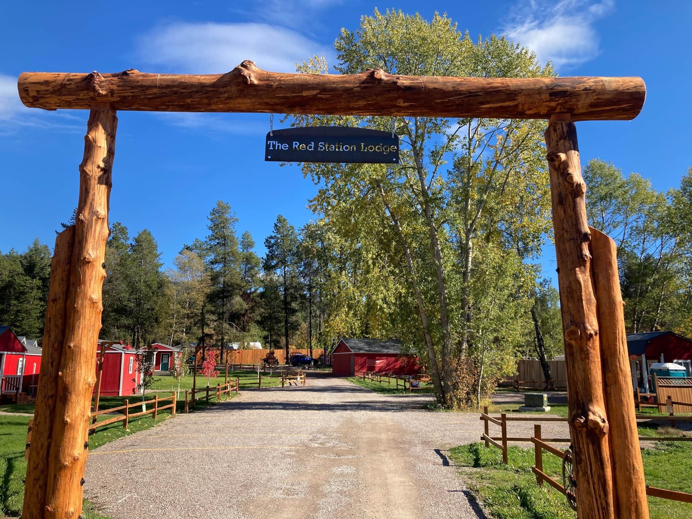 A rustic wooden archway with a sign reading "The Red Station Lodge."