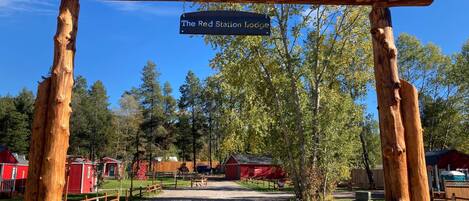 Un arco de madera rústico con un letrero que dice 'The Red Station Lodge'.