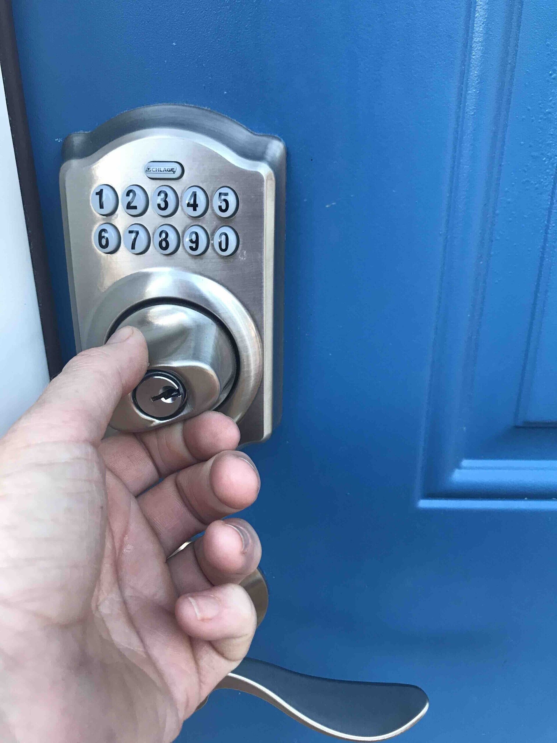 Eine Hand steckt einen Schlüssel in ein Schlage Türschloss.