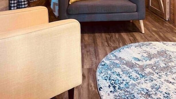 Une pièce confortable avec un lit, un canapé, un fauteuil et une table ronde.