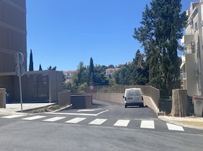 A street with a white van, a pedestrian crossing, and buildings in the background. - Apartment Iva (Dubrovnik)
