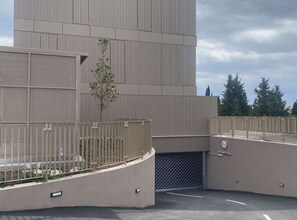 A modern building with a metal facade, a gated entrance, and a clear sky. - Apartment Iva (Dubrovnik)