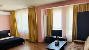 Ein Hotelzimmer mit Bett, Schreibtisch, Fernseher und Sofa.