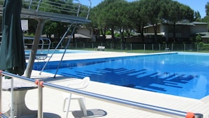 Une piscine avec un plongeoir et un poste de surveillance pour les sauveteurs.