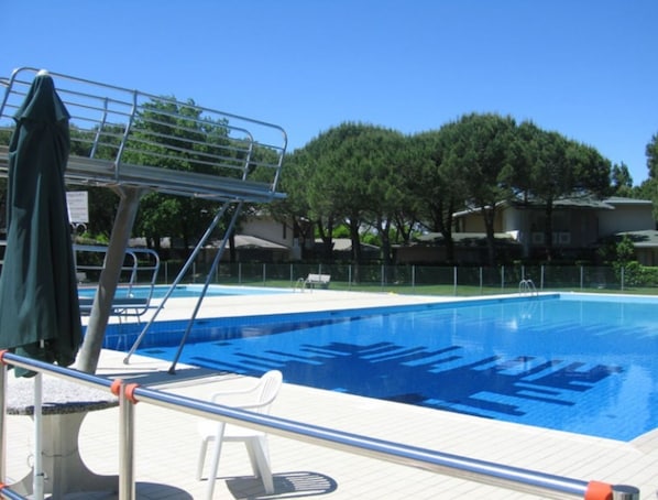 Une piscine avec un plongeoir et un poste de surveillance pour les sauveteurs.