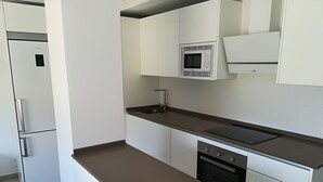 A modern kitchen with white cabinets, a built-in microwave, a stove, and a dishwasher.