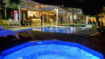 Relax by the pool with lounge chairs and a bar area offering a variety of seating options.