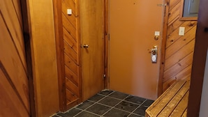 A small, enclosed room with wooden walls and a tiled floor.