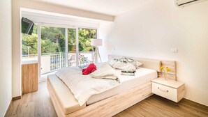 Un dormitorio con cama, mesita de noche y vistas a zonas verdes.