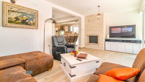 Una sala de estar con sofá, mesa de centro, televisor y chimenea.