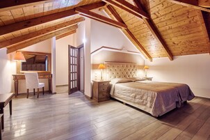 Una camera da letto con soffitto in legno, un letto, un comodino, una sedia e una scrivania.