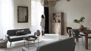 Un salon moderne comprenant un canapé, une table basse et un coin repas avec des chaises et une table.