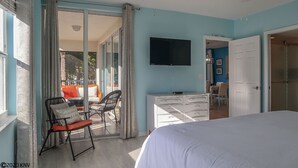 A bedroom with a bed, a dresser, a TV, and a sliding glass door leading to a balcony. - SUPER SUPER 3B/2B Hibiscus Pointe Condo With Water Views, Walk to Beach, Heated Pool! (Fort Myers Beach)