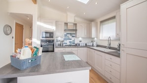 A modern kitchen with a skylight, white cabinetry, and a central island with a basket of items. - 2 Bedroom Sleeps 4 Lodge-smart Tv-hot Tub-dogs Ok (Lochwinnoch)
