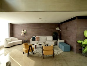 A modern living room with a sofa, armchairs, a coffee table, and a side table. - Hyatt Delhi Residences (New Delhi)