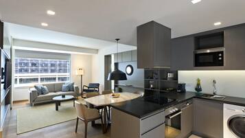 A modern kitchen with a central island, built-in appliances, and a dining area with a sofa and chairs.