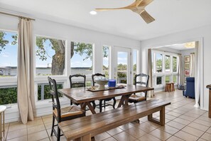 A dining area with a wooden table, chairs, and a view of the outdoors. - PK Lake Retreat | Private Beach, Bring Your Boat, Ultimate Game Room & Hot Tub (Graford)