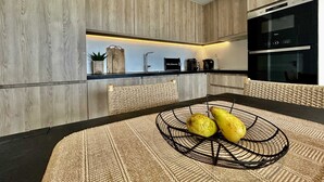 Une cuisine moderne avec des meubles en bois, un plan de travail noir et un four encastré.