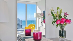 A modern room with a view of the sea, a vase with flowers, and a stack of books. - Modern 2BR Apartment | Steps to Brickell City Centre (Miami)