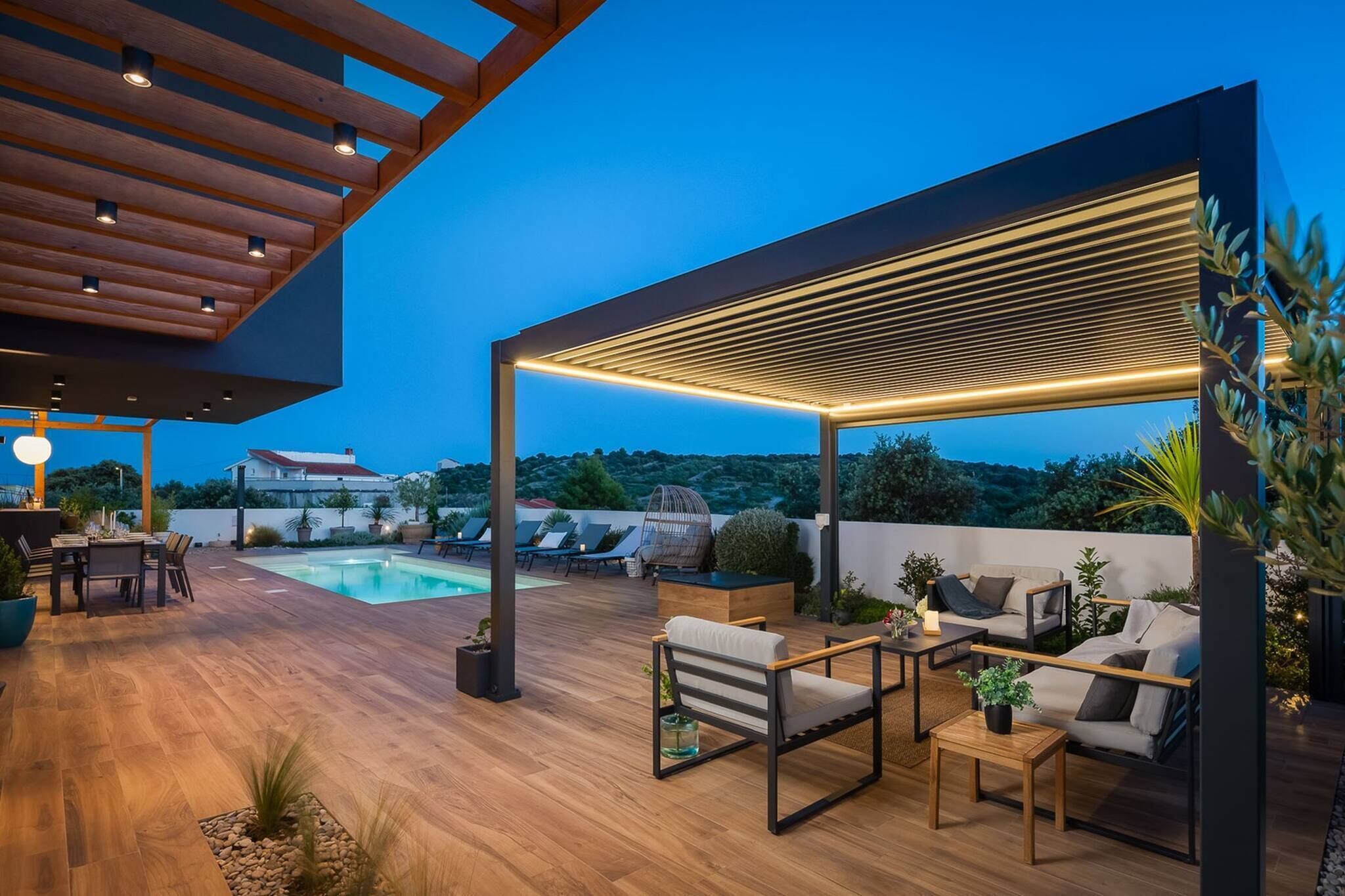 Eine Dachterrasse mit Pool, Sitzgelegenheiten im Freien und einer Pergola.