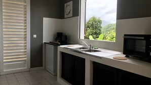 Une cuisine moderne équipée d’un four à micro-ondes encastré, d’une machine à café et d’un évier.