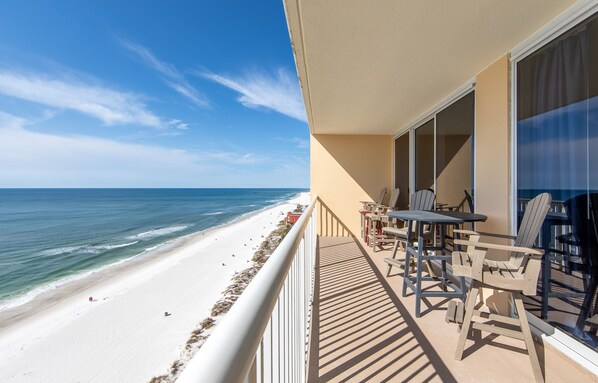 A balcony with a view of the beach and ocean.