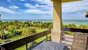A balcony with a view of the ocean and palm trees. - Great Beach View 2 Bedroom Condo (Longboat Key)