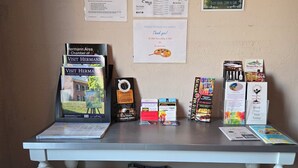 Ein Schreibtisch mit Broschüren, einem Schild für Ruhezeiten und einer Karte des Hermann-Wein-Trails.