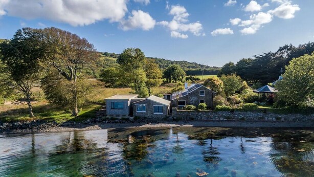 A lakeside property with two stone houses, clear water, and surrounding greenery. - Mulroe Cove - The Boathouse, Fisherman's Lane (Mulroe)