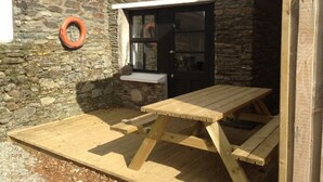 A stone building with a wooden bench and a door. - Mulroe Cove - The Boathouse, Fisherman's Lane (Mulroe)
