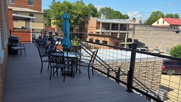 A wooden deck with outdoor seating and a view of buildings in the background. - The Pollock Suite is one of our four rooms. (Hermann)
