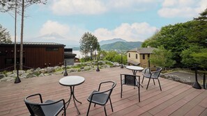 Eine Holzterrasse mit Sitzgelegenheiten und Blick auf einen Berg.
