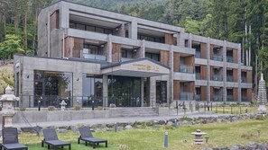 Ein modernes Gebäude mit flachem Dach, großen Fenstern und einer Stein-Fassade.