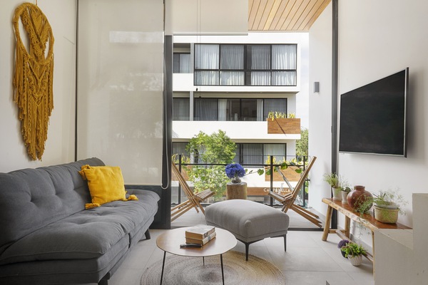 The bright sun soaked living space with a plush sofa that converts into a bed