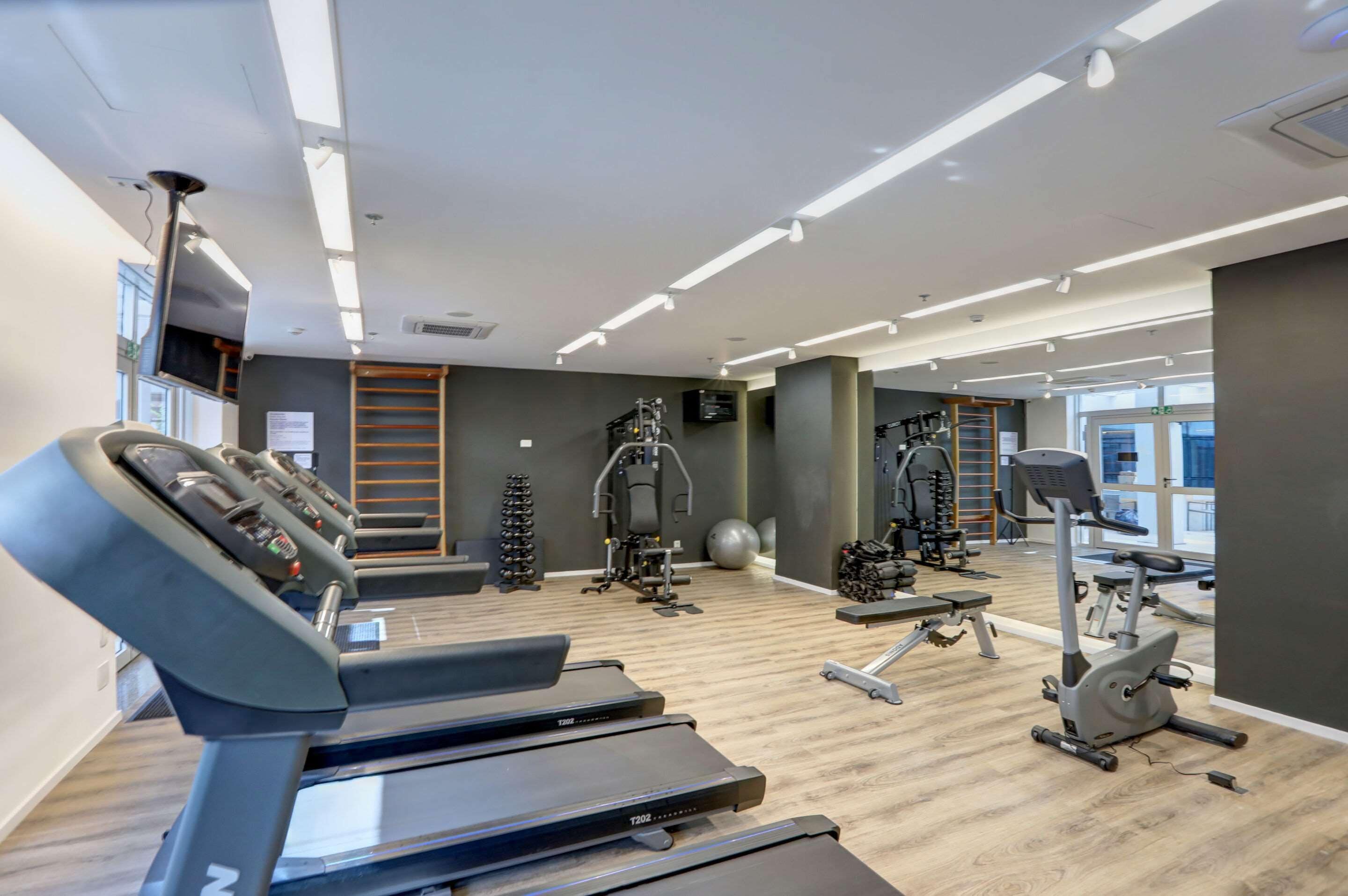 A gym with treadmills, exercise bikes, and weight machines.