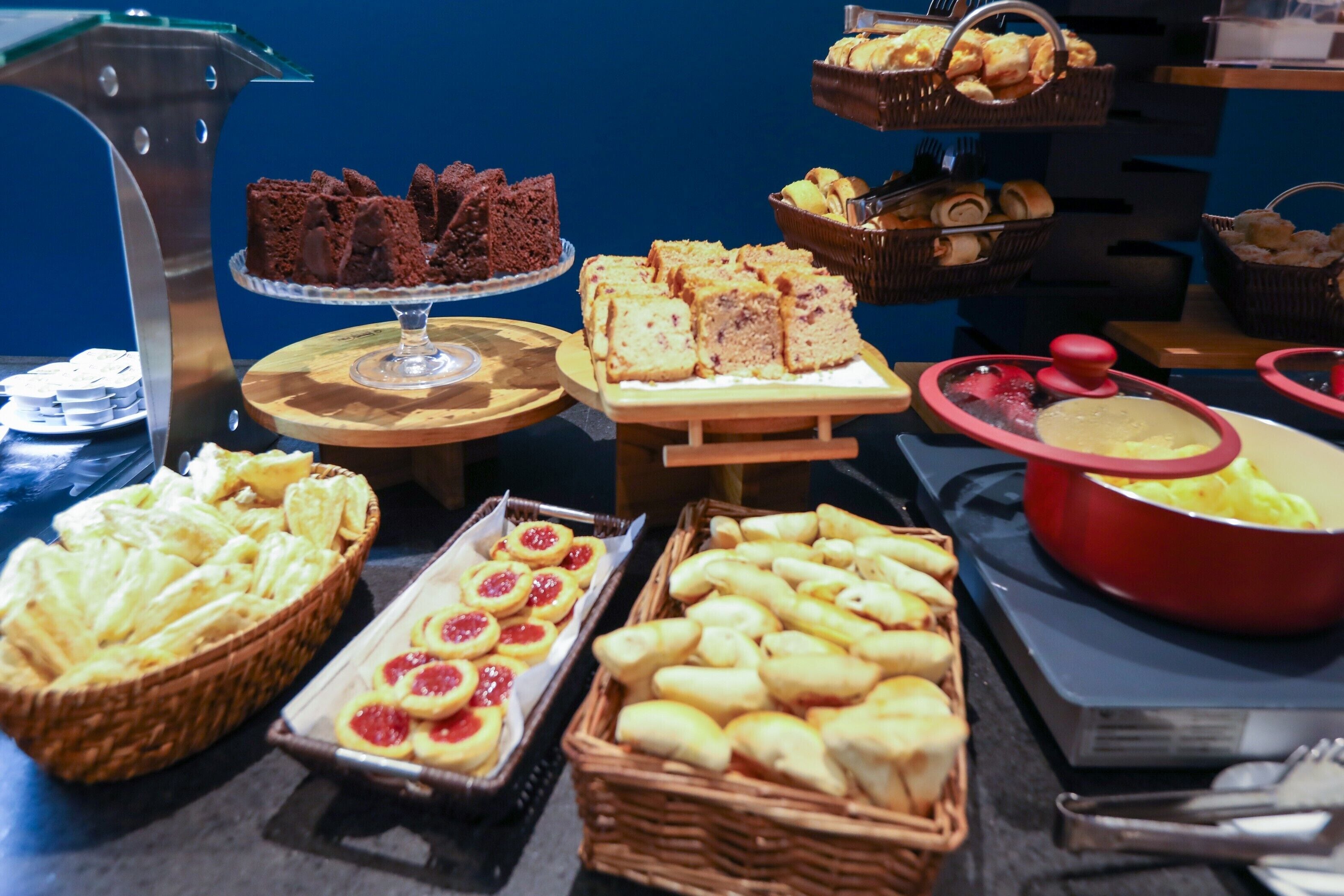 Un bufé con una variedad de productos horneados, como pan, pasteles y postres.