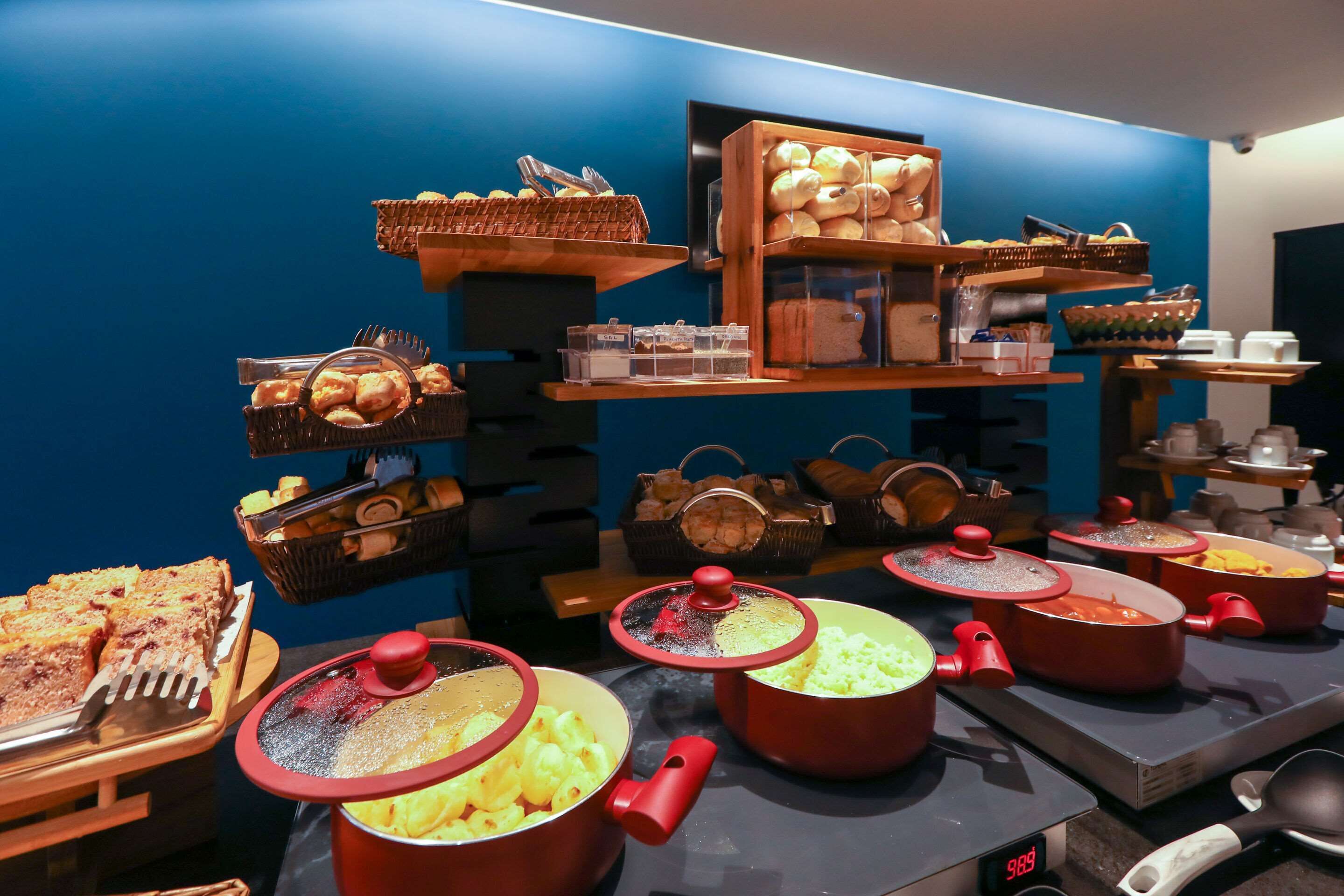Disposição de buffet com diversos alimentos e utensílios de cozinha.