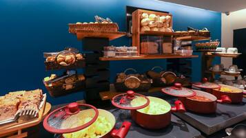 Disposição de buffet com diversos alimentos e utensílios de cozinha.