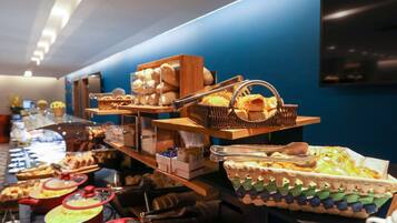 A buffet with various food items and utensils.