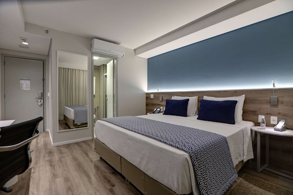A modern hotel room with a large bed, bedside tables, a desk, and a mirror. - Comfort Hotel Guarulhos - Aeroporto (Guarulhos)