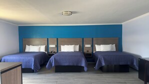 A hotel room with two beds, a desk, and a nightstand. - Carrizo Executive Inn (Carrizo Springs)