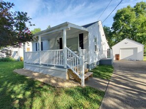 A single-story house with a front porch, a garage, and a small deck.