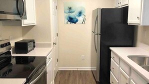 A compact kitchen with white cabinets, a black refrigerator, a microwave, a toaster, and a painting on the wall. - ★Posh Place ★ King Bed ★ Long Term Stays ★ Duke★ (Durham)