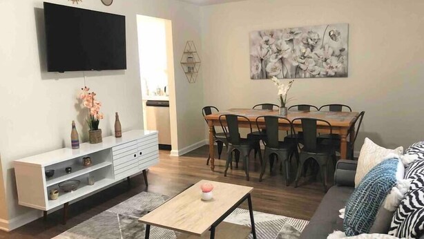 A modern living room with a flat-screen TV, a dining area with a wooden table and chairs, and a sofa with patterned cushions. - ★Posh Place ★ King Bed ★ Long Term Stays ★ Duke★ (Durham)