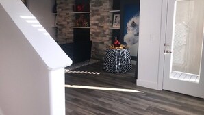 A modern interior with a stone accent wall, a fireplace, and a small round table with a polka dot tablecloth.