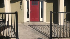 A building entrance with a red door, a mailbox, and a number '3861' on the wall.