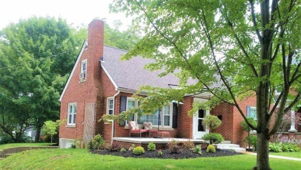 A brick house with a front porch, a lawn, and a tree. - Lovely Home: Sleeps 9, Fire-pit, Walk to Downtown, EKU, & Parks; 2miles to I-75 (Richmond)