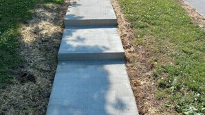 A concrete pathway leading to a brick building with a white door and windows. - Lovely Home: Sleeps 9, Fire-pit, Walk to Downtown, EKU, & Parks; 2miles to I-75 (Richmond)